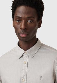 Lichtgrijs button-up shirt gemaakt van katoen, met een puntkraag, vijf knopen en een subtiel geborduurd logo op de borst.