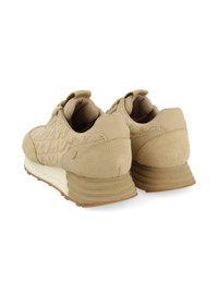 Zapatillas beige con una parte superior texturizada y acentos de ante suave, que presentan una media suela blanca y una suela de goma. Diseño simple y redondeado.
