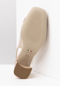 Scarpa con tacco alto nuda e lucida, con suola testurizzata e tacco a blocco. Presenta il marchio "NeroGiardini" e taglia 37. Prodotta in Italia.