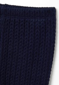 Tessuto a maglia blu navy con un motivo testurizzato e rigato. Il materiale appare morbido e caldo, con un bordo rifinito nella parte superiore.