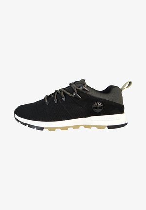 Scarpe sportive nere realizzate in tessuto e camoscio, con una intersuola bianca, suola nera, lacci rotondi e un logo decorativo di lato.