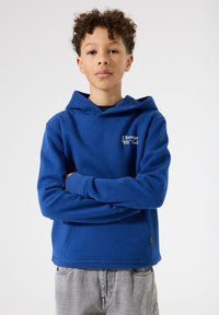 Sudadera azul con capucha hecha de una tela suave, con un bolsillo canguro frontal, puños acanalados y un pequeño logotipo en el pecho.
