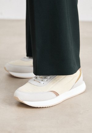 Sneakerid on koorelisest tekstilist ja hallist nahast pealsega, tugevdatud varbaosa, valge vaheosa ja heledat pruunid aktsendid. Sobivad igapäevaseks kandmiseks.