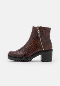 Brown leather ankle boot with croc-embossed texture, silver zipper, and chunky black rubber sole. Features a thick heel and braided accent.