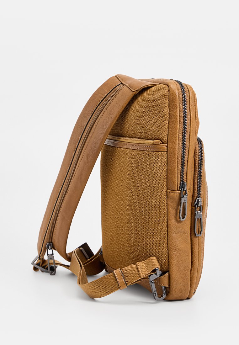 Borsa a messenger marrone con tessuto testurizzato e dettagli in pelle liscia, con due scomparti con cerniera e una tracolla regolabile.