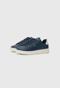 Mørkeblå lær-sneakers med hvite gummisåler, med mørkeblå lisser, rund tå og minimal perforering på sidene.