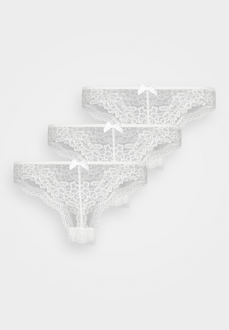 Weißes Spitzenunterwäsche-Set, mit gewellten Kanten und floralen Mustern, verziert mit kleinen Schleifen vorne. Drei Teile ausgestellt.