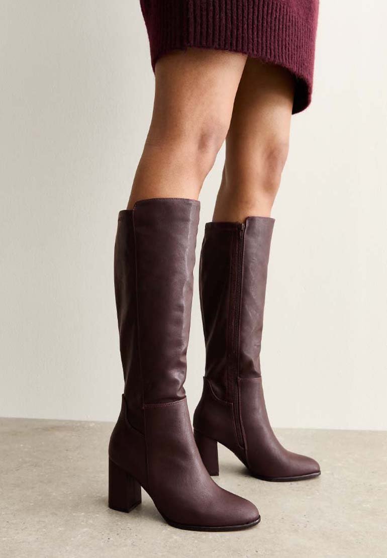 Botas altas hasta la rodilla de cuero burdeos, con punta cuadrada y tacón ancho, que incluyen una cremallera lateral y una textura suave.