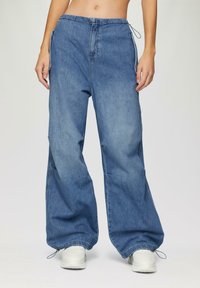 Lichtblauwe denim broek met een relaxte pasvorm, voorzien van een elastische tailleband, trekkoordaccenten en elastische manchetten bij de enkels.