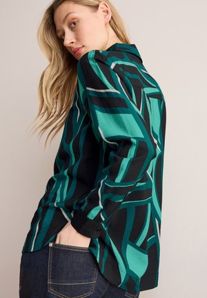Camicia button-up in teal e nero con motivi astratti, caratterizzata da una vestibilità ampia, maniche lunghe e colletto classico, realizzata in tessuto leggero.
