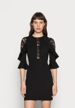 Vestido preto com detalhes em renda nas mangas e na frente, com bordas de mangas em babados e uma silhueta ajustada. Textura suave por todo o vestido.