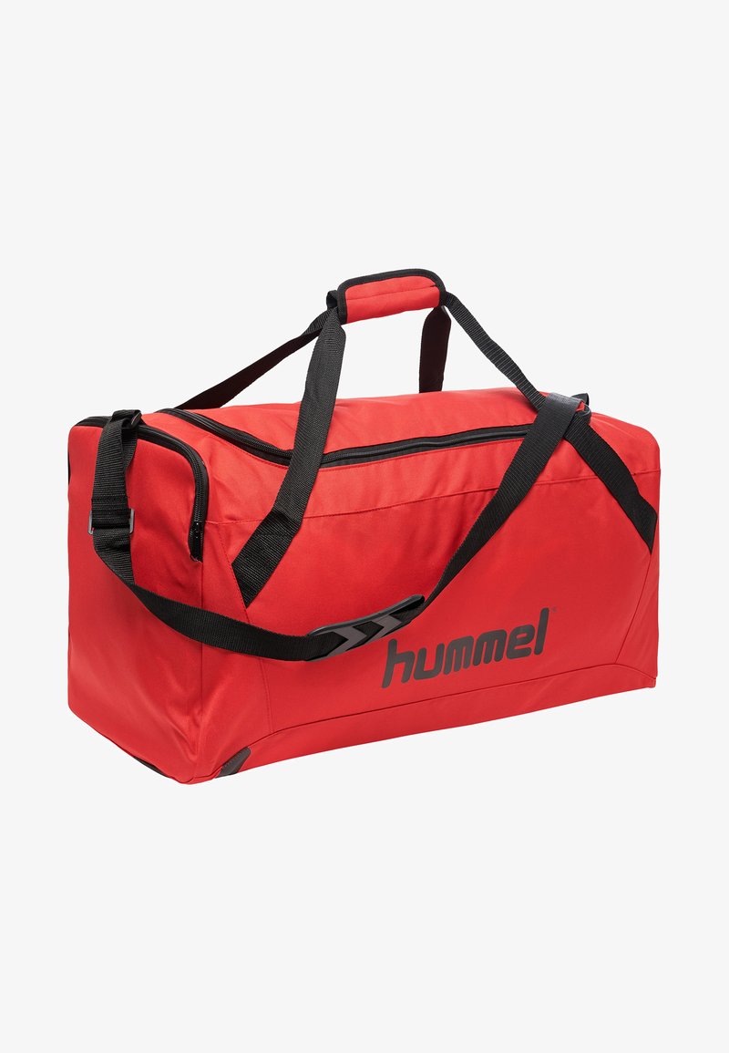Saco de desporto vermelho feito de tecido durável com alças e fecho de correr pretos. Apresenta um logótipo de lado, formato retangular e pegas robustas.