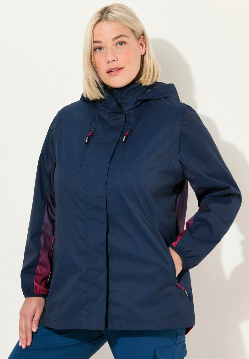 Veste imperméable bleu marine avec capuche, dotée de panneaux latéraux bordeaux, de poches avant, de fermetures éclair et de poignets élastiques pour un ajustement réglable.