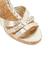 Gouden leren wedge sandaal met gevlochten banden en kurk-textuurzool. Ontwerp met open teen en een gladde, glanzende afwerking op de banden.