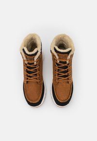 Brown leather boots with faux fur lining, black accents, and orange laces. Features a rounded toe and a contrasting white sole.