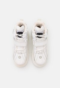 Valged kõrge ülemine sneakersid sileda lakina, ümmargune varvas, reguleeritav Velcro rihm, paelad ja logo märk keelel.