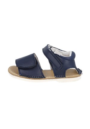 Sandalia de piel azul marino con tiras de velcro, diseño abierto, suela beige y detalles de costura blanca. Adecuada para el tiempo cálido.