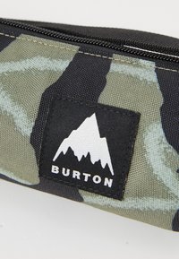Green and black camo-patterned pencil case with a zip closure. Features a black patch with a white mountain logo and brand name "BURTON."
