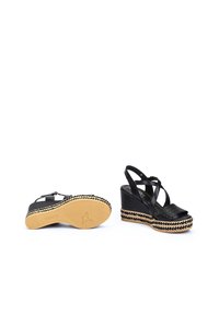 Sandales compensées noires avec des lanières croisées, dessus en tissu texturé, détail en jute tressé sur la plateforme et semelle en caoutchouc.
