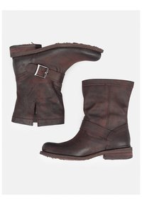 Botas de cuero marrón hasta el tobillo con un acabado texturizado, un hebilla lateral y un diseño dividido cerca de la parte superior. Tacón bajo apilado para mayor estabilidad.