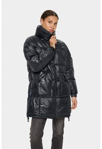 Pūkains melns mētelis ar augstu apkakli un rāv�ējslēdzēja aizdari. Aprīkots ar divām priekšējām kabatām un elastīgām aprocēm. Spīdīgs audums ar šūtu rakstu.