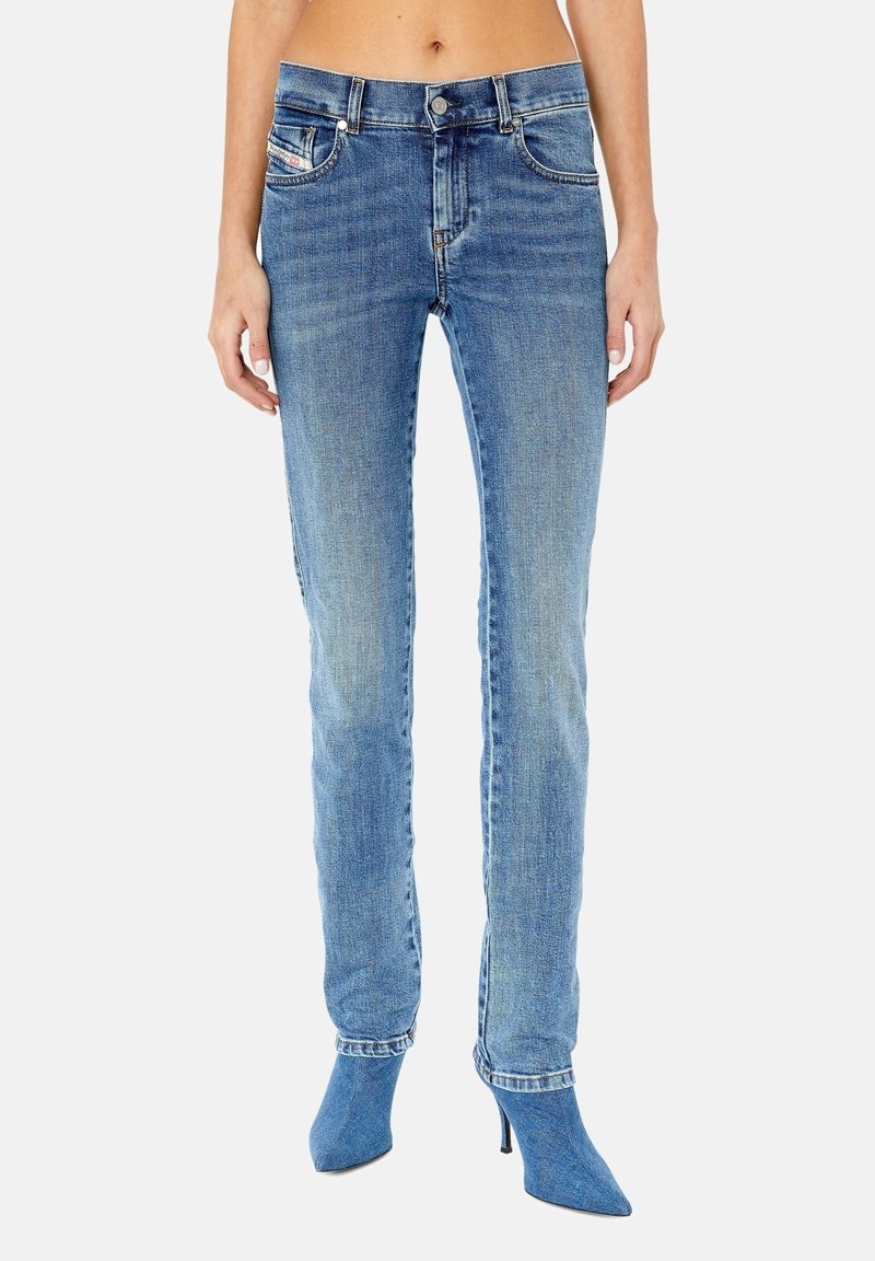 Ljusblå jeans i denim med rak benform, fem fickor och subtila blekningar. Matchade med spetsiga klackskor för extra höjd.