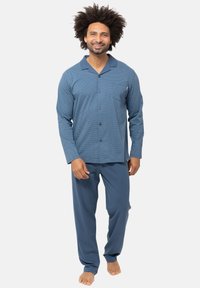 Sinipeläinen kuvioitu yöasu, joka sisältää pitkähihaisen napituspaidan ja siihen sopivat housut. Paita on varustettu rintataskulla ja pehmeällä kangasrakenteella.