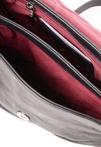 Black leather handbag with a maroon fabric interior, featuring two compartments, a zippered pocket, and a silver snap closure.