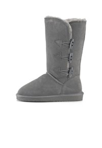 Stivaletto in suede grigio con gambale corto, tre anelli decorativi sul lato e una morbida fodera interna. Suola piatta per comfort e supporto.