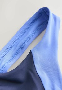 Kaks lõiku ujumisriide kangast: üks helesinisest ja teine tumesinisest. Paindlik tekstuur, serval õmblusega detail.