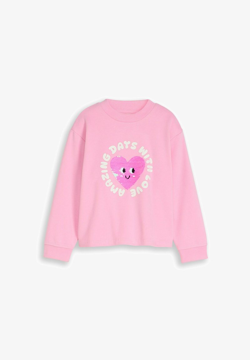 Bluză roz cu mâneci lungi, având o inimă zâmbitoare din paiete și text alb în jurul inimii, într-un cerc, cu mesajul „Zile uimitoare cu dragoste”.