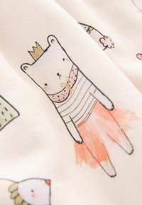 Tkanina bawełniana o jasnokremowym tle z kolorowymi ilustracjami niedźwiedzi i ptaków. Niedźwiedź nosi koronę i pasiastą koszulę z różową tutu.