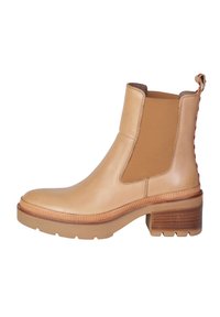 Stivale alla caviglia in pelle tan con pannelli elastici laterali, tacco testurizzato e linguetta posteriore. Presenta una suola in gomma robusta e un design elegante.