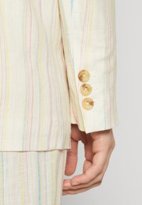 Lichtgekleurde linnen blazer met multicolore verticale strepen. Voorzien van drie ronde gele knopen op de manchetten.