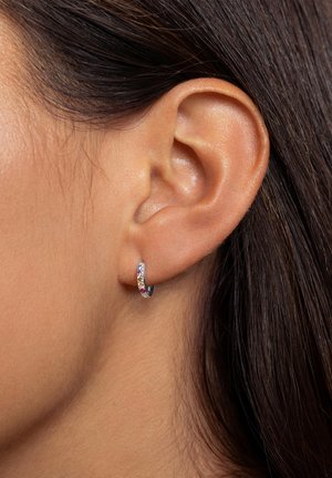 Orecchino a cerchio in argento con una fila di gemme multicolori, superficie liscia, diametro ridotto e un design semplice.