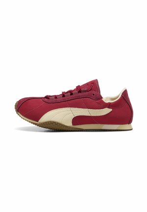 Baskets bordeaux profil bas avec logo Puma beige, fermeture à lacets et semelle marron texturée, vue de côté sur fond blanc.