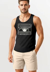 Black tank top featuring a mountain and sun graphic in cream, with the word "NEVERLESS" at the bottom. Model wears beige shorts.