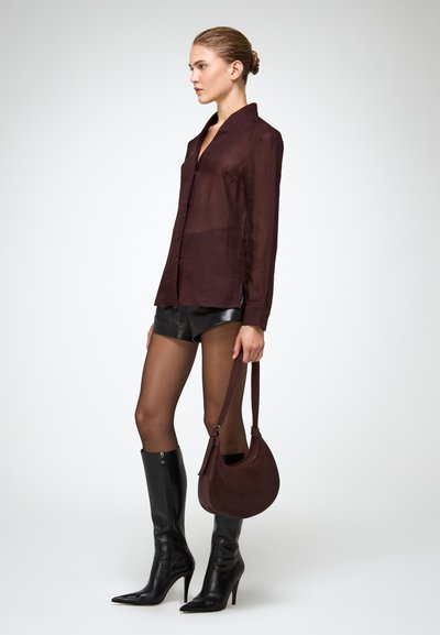 Sheer burgundy button-up shirt, leather black shorts, thigh-high black leather boots, and a curved burgundy handbag. Smooth textures throughout.