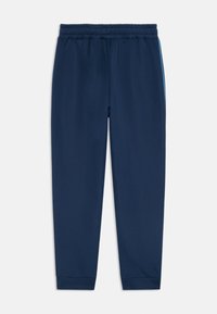 Pantalons de jogging bleu marine en matière extensible, dotés d'une taille élastique, de jambes fuselées et de rayures latérales bleu clair.