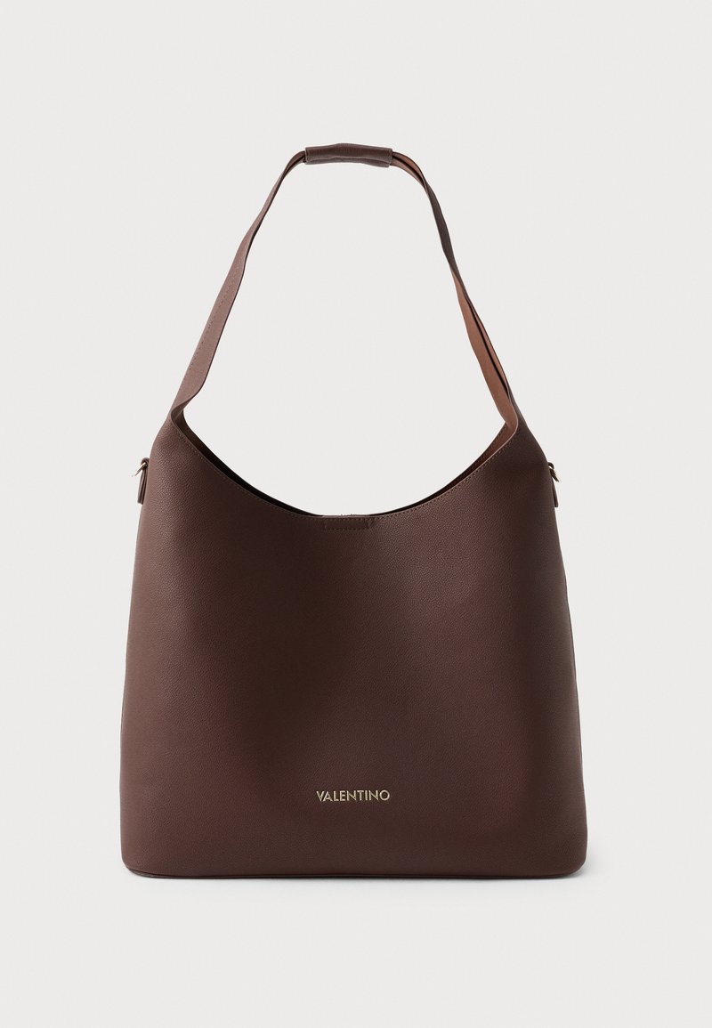 Brown leather shoulder bag with a curved silhouette and flat handle. Features a gold logo on the front and a textured finish.