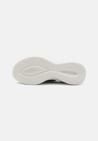 Semelle de sneaker en caoutchouc blanc avec un motif de grip texturé et une légère courbure. Bord lisse et aucune marque visible.