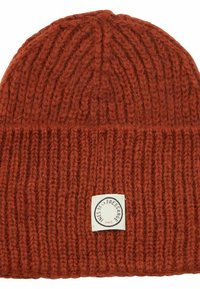 Bonnet en tricot couleur rouille avec texture côtelée, présenté avec une étiquette de marque sur le bord replié. Fabriqué en matériau doux et chaud.