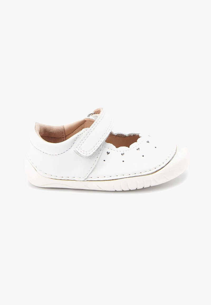 Chaussure en cuir blanc avec un bout arrondi, sangle Velcro et designs en forme de cœur découpés. Comprend une semelle en caoutchouc texturé et des détails cousus.