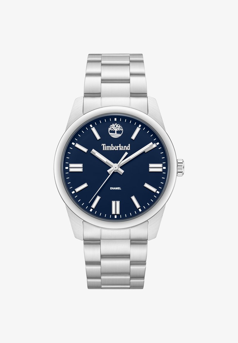 Montre-bracelet en métal argenté avec cadran bleu, index argentés, logo Timberland, et trois aiguilles affichant l'heure 10:09:38.