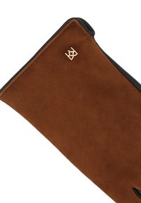 Brūns zamšādas cimds ar melnu ādas apdari, ar mazu zelta logotipa akcentu tuvu plaukstas locītavai. Mīksta tekstūra un pieguļošs dizains.