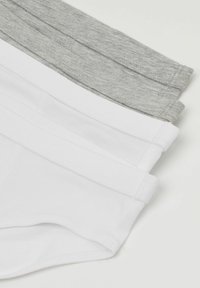 Trois paires de sous-vêtements pour hommes pliées : une blanche, une gris clair et une gris foncé. Fabriquées en coton avec des ceintures élastiques sans couture.