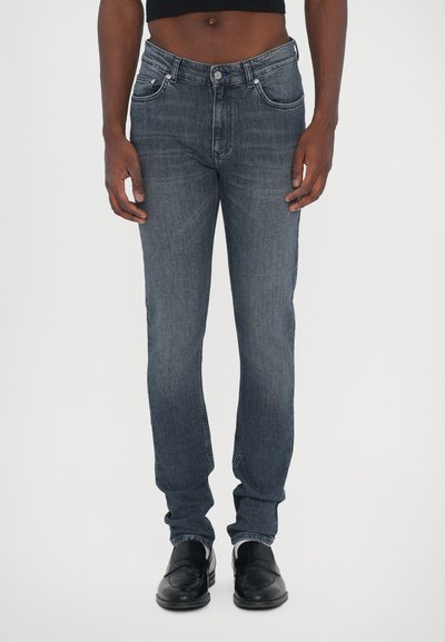 Slim-fit, marineblauwe denim jeans met een subtiele wassing; voorzien van voorzakken, een rits met knoopsluiting en een taps toelopende pijp.
