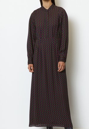 Robe longue et sombre avec un motif géométrique rouge et vert. Dotée d'un col et de manches longues, confectionnée dans un tissu léger.