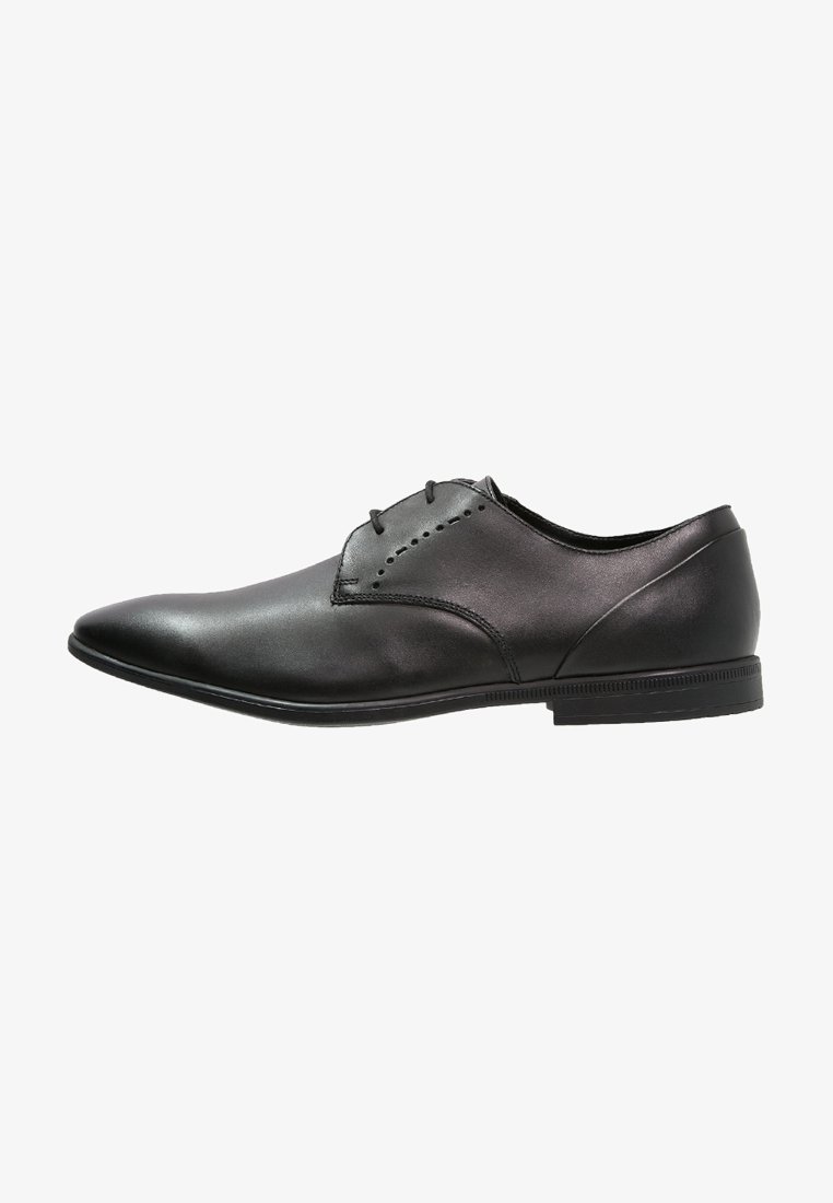 Chaussure habillée pour homme en cuir noir avec bout pointu, design à lacets et talon bas, vue de profil sur fond blanc.