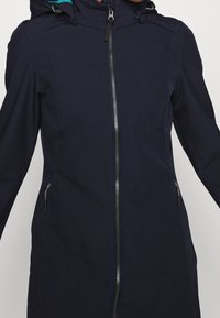 Giacca con cappuccio blu navy con cerniera integrale, dotata di tasche laterali e texture liscia. L'interno del cappuccio ha una fodera turchese a contrasto.